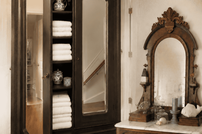 Antique dark-wood wardrobe displayed beside its matching marble-top dresser and ornate mirror.